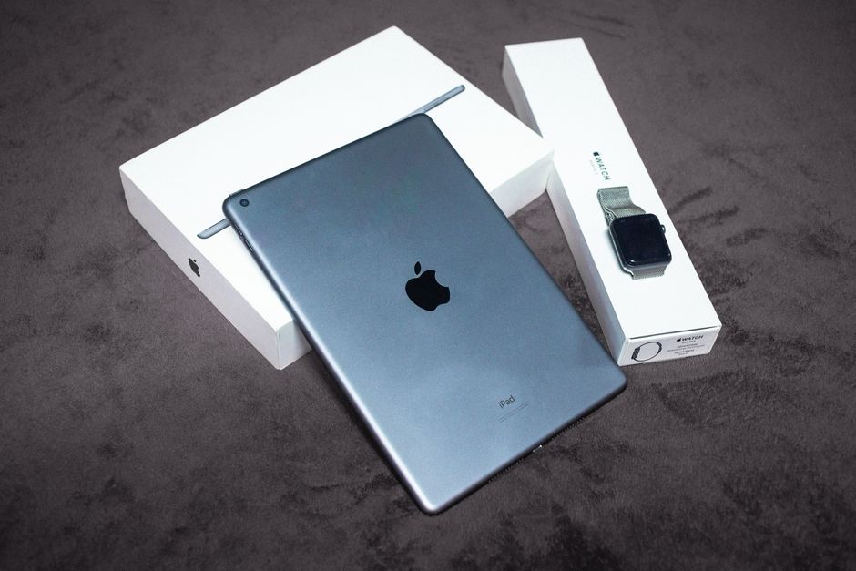 iPad and Apple Watch displayed on a black background, highlighting sleek design and packaging.